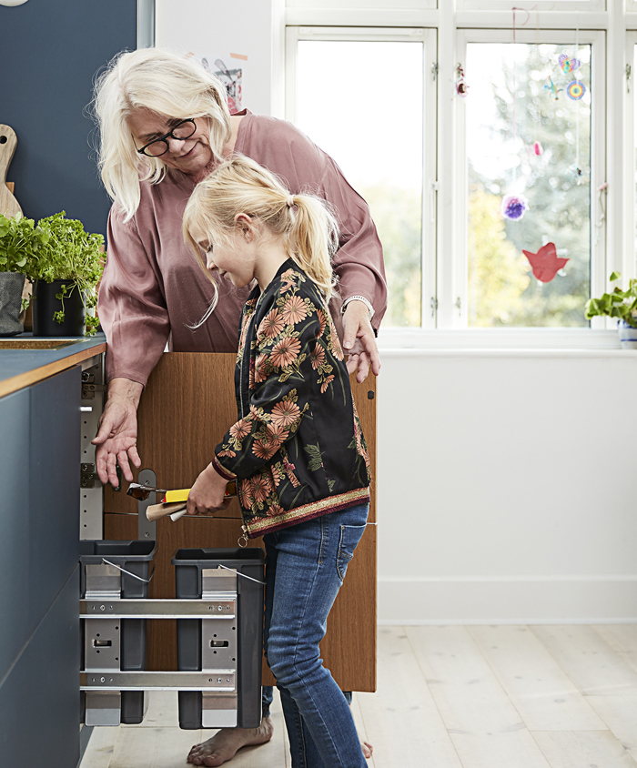 Bedstemor hjælper barnebarn med at sortere affald i køkkenet