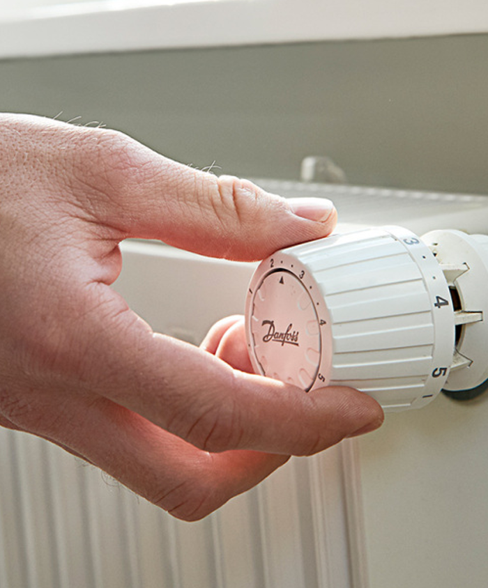 Stor pige læser ved radiator