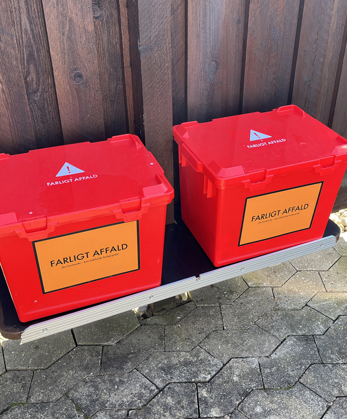 Billede af to røde kasser til farligt affald i sorteringsgård