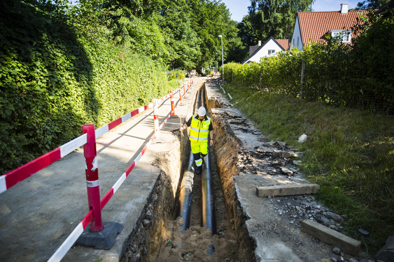 Medarbejder i gang med gravearbejde for fjernvarmen